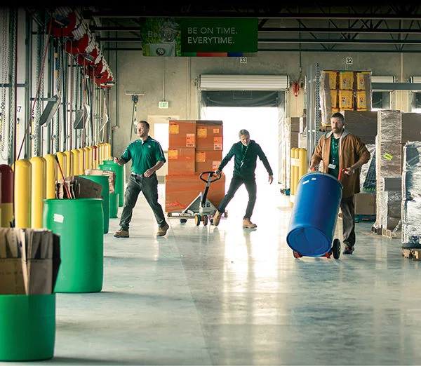 ODFL employees moving freight and materials inside a terminal near loading docks.